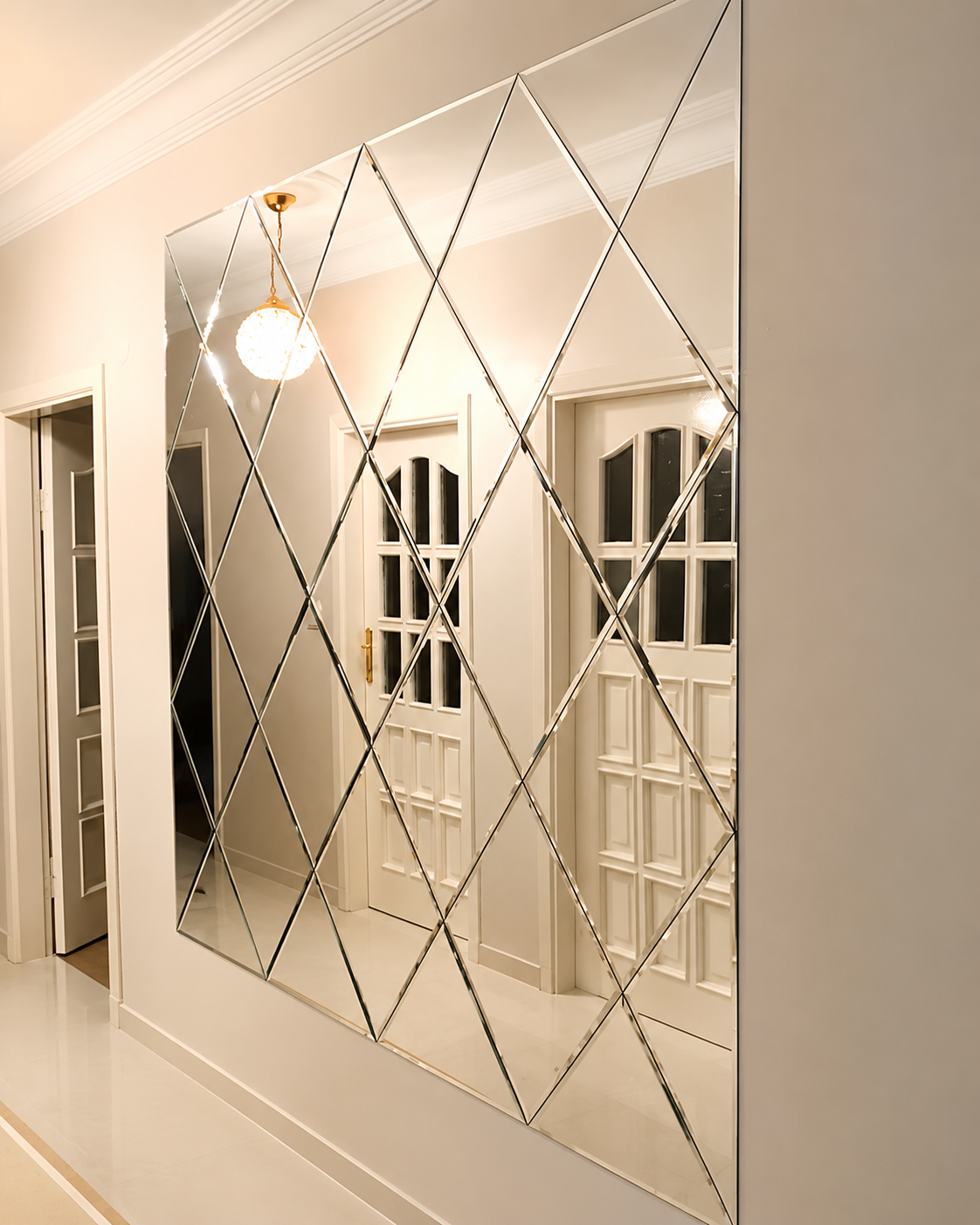 Custom floor-to-ceiling diamond-pattern mirrored feature wall installed in a bright residential hallway.